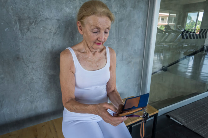 Femme âgée lisant une newsletter sur son smartphone ©Shutterstock