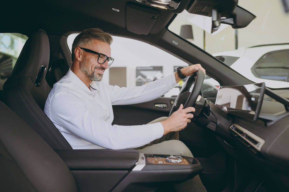 Homme senior dans une voiture électrique ©Shutterstock